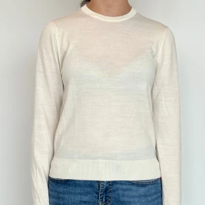 Vit stickad tröja från Uniqlo - Säljer en vit stickad tröja från Uniqlo i storlek XS! Den är som ny fast jag har haft på mig det några gånger💕 I bilden ser tröjan mer genomskinlig ut fast det är inte mycket så i verkligheten :) 