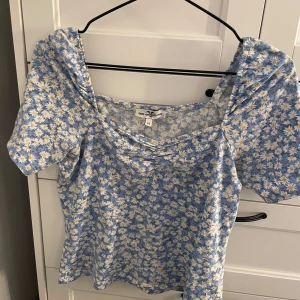 Blommig topp från Hampton Republic - Söt blommig topp i blått och vitt från Hampton Republic. Toppen har korta ärmar och ett fint blommönster med små vita blommor. Perfekt för en somrig look!