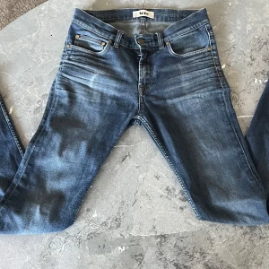 Blå jeans från Acne - Snygga blå jeans från Acne med klassisk femficksdesign och knappgylf. De har en stilren look med en lätt tvättad effekt som ger en avslappnad känsla. Perfekta för en trendig vardagsstil. W29/L32