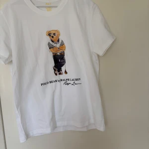 Polo Bear Ralph Lauren t shirt - Säljer en vit t-shirt från Ralph Lauren med ett sjukt fett Polo Bear tryck på framsidan. Knappt några effekter mer än att den är använd. För mer info är det bara att höra av sig och priset är inte hugget i sten.