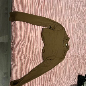 Brun långärmad tröja från Divided - Säljer en brun långärmad tröja från Divided. Perfekt för höst och vinter med sin enkla design och bekväma passform. Tröjan är tillverkad i ett mjukt material som gör den skön att bära hela dagen.