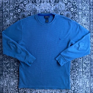 Blå sweatshirt tröja från Polo Ralph Lauren - Säljer en snygg blå långärmad tröja från Polo Ralph Lauren. Tröjan är tillverkad i 100% bomull. Storlek M och passar perfekt till att ha skjorta under. Väldigt bra skick. Hör av dig vid frågor!
