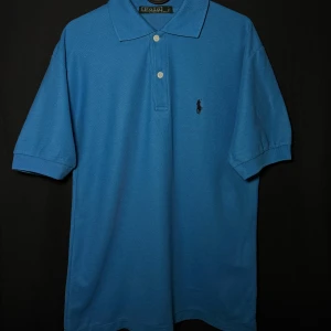 Ralph Lauren piké | Blå | Slim Fit| Stl M - Läs nedan för mer info!😊  Säljer en klassisk blå pikétröja från Ralph Lauren med korta ärmar och knappar framtill. Tröjan har det ikoniska broderade logotypen på bröstet. Perfekt för en stilren look.  Produktinformation:  ✅ Märke: Ralph Lauren  ✅ Storlek: M  ✅ Färg: Blå, Turkos ✅ Material: Bomull ✅ Passform: Slim fit – perfekt att styla med jeans eller chinos. ✅ Skick: Mycket bra skick, knappt använd  Frakt och betalning: 📦 Snabb leverans – skickar inom 1-2 dagar efter beställning📦