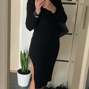 Snygg ribbad klänning i nyskick. S - Snygg svart ribbad klänning med långa ärmar och dekorativa knappar vid ärmsluten. Perfekt för en stilren look. Klänningen har en enkel och elegant design som passar till många tillfällen. Klänningen är figursydd och har en slits i sidan. En gång använd. Som ny Tvättad 🚫Djurfritt och rökfritt hem 📍Kan mötes upp i Mölnlycke 📬Kan skickas mot fraktkostnad