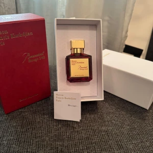 Maison Francis Kurkdjian Baccarat Rouge 540 - Exklusiv parfym från Maison Francis Kurkdjian, Baccarat Rouge 540. Flaskan är elegant i röd glas med en gyllene kork och etikett. Den kommer i en lyxig förpackning som utstrålar sofistikation och stil.