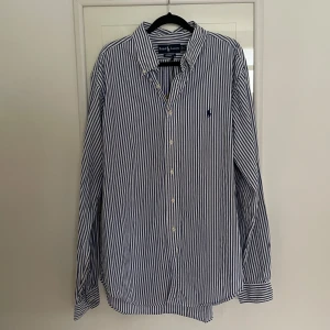Randig skjorta, Ralph Lauren - Snygg skjorta från Ralph Lauren i klassiskt blått och vitt randigt mönster. 