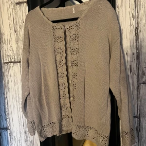 Beige stickad kofta med spetsdetaljer - Säljer en mysig beige stickad kofta med vackra spetsdetaljer längs kanterna och ärmsluten. Perfekt för att hålla sig varm och stilren under kyligare dagar. Passar bra till både jeans och kjol. 🧶✨