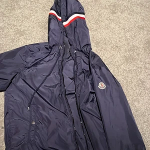 Mörkblå vindjacka från Moncler - Säljer en vindjacka från Moncler. Jackan är stilren. Perfekt för blåsiga dagar.