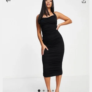 Svart tight klänning - Snygg svart tight klänning med halterneck-design. Perfekt för en kväll ute eller en speciell tillställning. Klänningen har en smickrande passform och når till knäna. Från asos och aldrig använd
