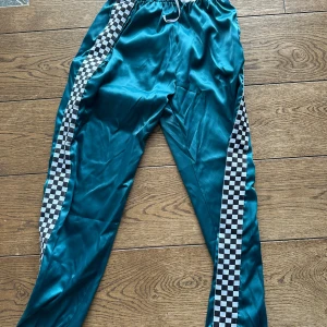 Siden byxor  med rutigt mönster - Byxorna har en elastisk midja med snörning för justerbar passform. Perfekta för en sportig look!