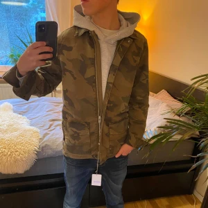 Ny Zadig & Voltaire Camouflage Jacka - Säljer denna sjukt snygga camouflage jackan från Zadig & Voltaire med en högkvalitativ dragkedja, krage och tillåter mängder av personlig touch med alla knappar som finns. Jackan har långa ärmar och fyra stora fickor framtill samt 2 stora innuti. Perfekt för en avslappnad stil näst intill hela året om. Lapparna från butik sitter kvar och jackan är näst intill oanvänd, skick 10/10. Nypris ligger runt 4000-4500 kronor. Tveka inte på att höra av dig vid frågor eller funderingar! ⭐️