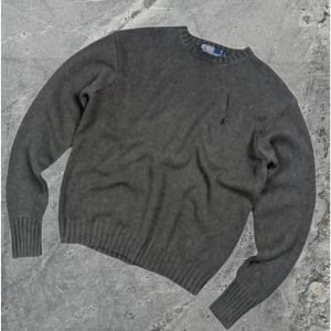 Stickad tröja från Ralph Lauren - Säljer en snygg grå stickad tröja från Ralph Lauren. Den har en broderad logga på bröstet och ribbade muddar vid ärmslut och nederkant. Perfekt för kyliga dagar! Inga defekter på tröjan, den är i storlek S! Skriv för frågor 