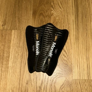 Svarta Monolit Benskydd - Säljer ett par svarta benskydd från Monolit i kolfiber. De väger väldigt lite och passar bra på smalbenet.