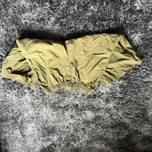 Olivgröna shorts med elastisk midja - Snygga olivgröna shorts med elastisk midja och praktiska fickor. Perfekta för en avslappnad stil. Tillverkade i bomull för en bekväm känsla.