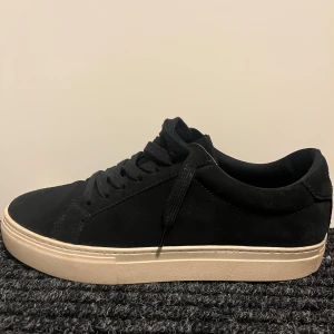 Svarta sneakers från Vagabond - Snygga svarta sneakers i mocka från Vagabond med en stilren design. Skorna har en beige sula och klassisk snörning. Perfekta för en avslappnad stil. Är öppen för frågor! Skorna är storlek 39 men passar ungefär som 40,5. Pris kan diskuteras! 