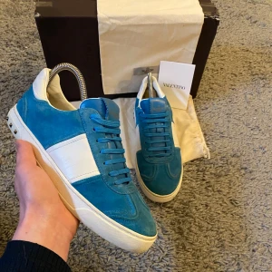Blå Valentino Flycrew skor - Säljer nu dessa riktigt feta och trendiga Valentino Flycrews i storlek 41 för 3699. Skorna har alla nitar kvar vilket är sällsynt och alla tillbehör i bild ingår: box (lite skadad), två dustbags och Valentino kort. Vid frågor och funderingar är det bara att höra av sig!