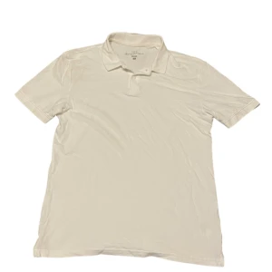 Vit pikétröja från H&M - Säljer en klassisk vit pikétröja från H&M med krage och knappar. Perfekt för en stilren look. Tröjan är kortärmad och tillverkad i ett bekvämt material.