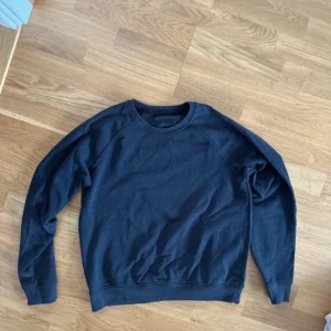 Mörkblå sweatshirt - Säljer en stilren mörkblå sweatshirt med rund hals och långa ärmar. Perfekt för en avslappnad look. Passar bra till jeans eller joggers.