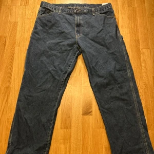Blå jeansbyxor från Dickies - Säljer ett par klassiska blå jeansbyxor från Dickies. Byxorna har en normal passform med flera praktiska fickor. Köpte dessa på en vintage affär för 750kr. Byxorna är vintage ifrån 90-talet och är svåra att hitta. Pris kan självklart diskuteras!