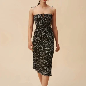 Adoore klänning Antibes  - Snygg axelbandslös klänning med blommigt mönster. Klänningen har en smickrande passform och knytband vid axlarna för extra detalj. Perfekt för sommarens alla tillfällen! Använd vid  2 tillfällen 