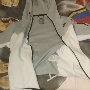 Nike tech  - Säljer min gråa och vita nike tech. Den är storlek M och är i bra skick. Den är en skön och perfekt huvtröja för den kommande sommaren.