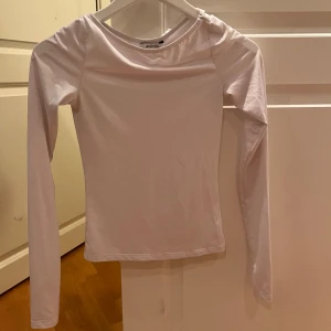 Vit långärmad topp från Monki - Säljer en stilren vit långärmad topp från Monki. Är i tränings material, sitter väldigt slim men skönt☺️