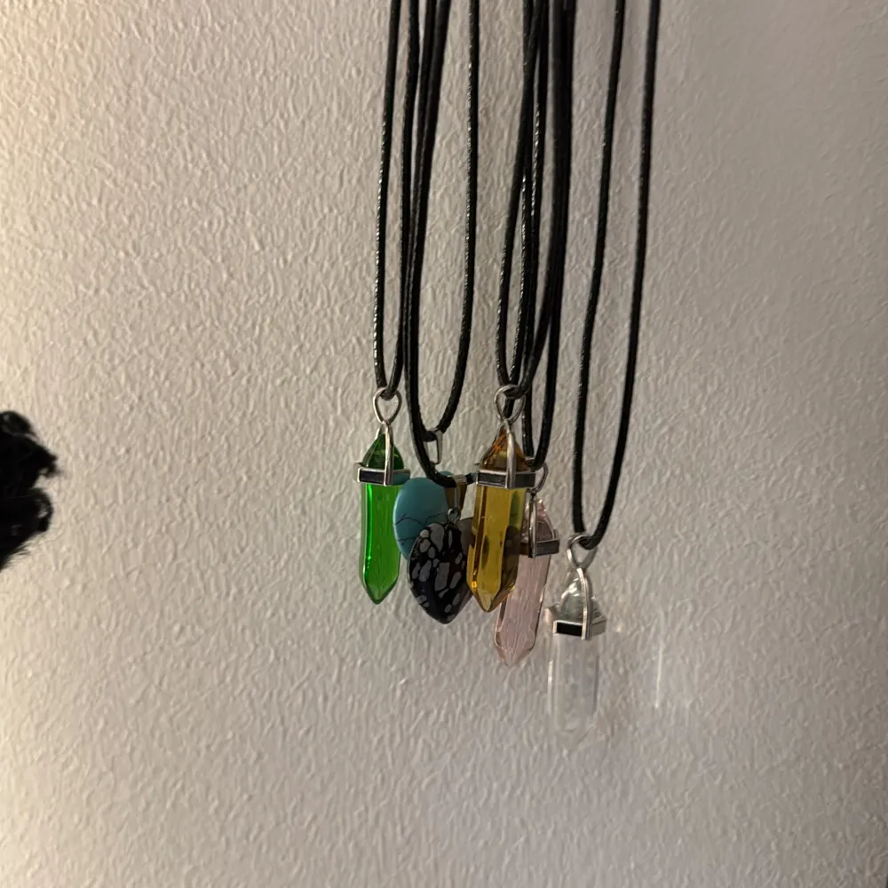 Säljer 6st halsband med kristall- och hjärtformade hängen i olika färger. Kristallerna finns i grönt, gult, rosa och klart, medan hjärthalsbanden är i svart och turkos. Perfekta för att lägga till en färgglad touch till din stil. De är väldigt fina och är bra till variation 🌟🌟🌟🌟🌟de är ej äkta. Asusteet.