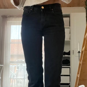 Svarta jeans med låg midja - Snygga svarta jeans med låg midja och rak passform. Perfekta för en avslappnad stil. De har en klassisk design med fem fickor och knappgylf. W25 L32