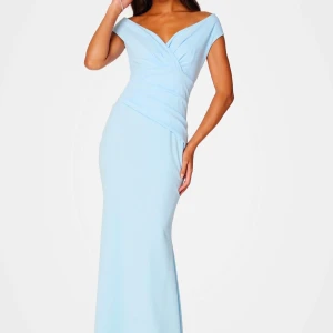 Ljusblå långklänning - Helt ny med prislappen kvar ljusblå långklänning med omlott-design och offshoulder-stil. Perfekt för speciella tillfällen med sin smickrande passform och mjuka material. Passar även bra till bal!