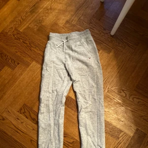 Grå mjukisbyxor Gant - Säljer ett par bekväma grå mjukisbyxor från Gant. Perfekta för en avslappnad dag hemma eller på språng. Byxorna har en enkel och stilren design.