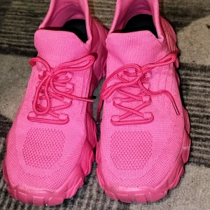Rosa sneakers med snörning - Snygga rosa sneakers med snörning och en sportig design. Skorna har en stickad ovandel och en robust sula som ger bra grepp. Perfekta för en färgglad och bekväm stil.