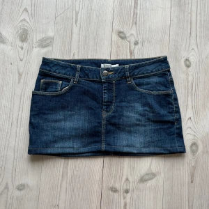 Mörkblå lågmidjad jeanskjol  - Blå lågmidjad jeanskjol från Esprit som jag har sytt upp från en längre kjol. Fint skick. Kan inte hitta storlek men skulle säga S/M. Tvärs över midjan är det 39 cm och den är 29 cm lång. Använd gärna köp nu!