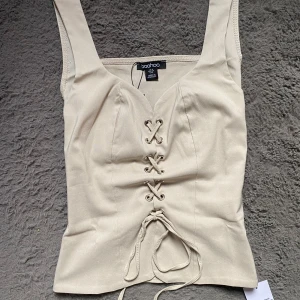 korsettopp med snörning - Helt ny korsettopp med snörning framtill, säljer då jag har en liknande från zara. Toppen har breda axelband och en figurnära passform som framhäver midjan. Alla lappar är kvar på 💕