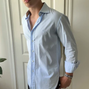 Burberry skjorta ljusblå  - Modellen är 180,75 kg och bär 40 vilket motsvarar ungefär M. Kom med frågor. Inga defekter eller skavanker! 