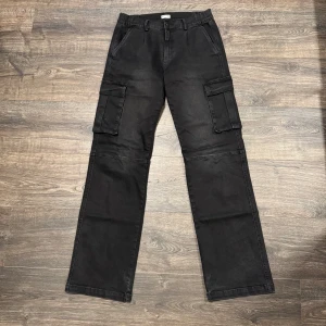 Svarta cargobyxor från Madlady - Cargobyxor från Madlady. Storlek 38, tall!! De har lite smuts på vänster ficka men det bör gå att tvätta bort :)