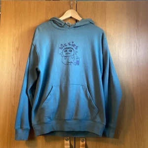 Blå hoodie från Dickies med tryck - Säljer en blå hoodie från Dickies med ett unikt tecknat monster-tryck. Tröjan har huva med snörning, känguruficka och är långärmad. Priset går att diskutera!