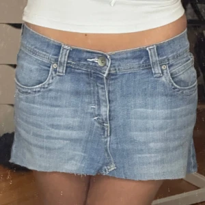  Low waist jeanskjol  - 🦋Omsydd🦋                                                                      Jättesöt jeanskjol som är low waist med fina fickdetaljer.                                                           Bredd rakt av: 41 cm Höjd fram: 24 cm Höjd bak: 31 cm