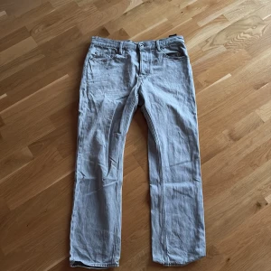 Ljusblå jeans från G-Star RAW 31/30 - Säljer ett par ljusblå jeans från G-Star RAW i klassisk femficksmodell. Jeansen har raka ben, normal passform och är tillverkade i bomull. Snygga detaljer på bakfickorna och diskret logga på bakre etiketten. Perfekta för en avslappnad stil. Pris kan diskuteras vid snabb affär 