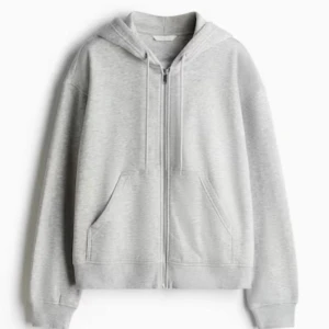 Ljusgrå hoodie med dragkedja H&M XS - Säljer en ljusgrå hoodie från H&M i storlek XS. Tröjan har huva med snörning, dragkedja framtill och två stora fickor. Perfekt för chill dagar och enkel att matcha med allt. Mjuk bomullsblandning och klassisk passform.
