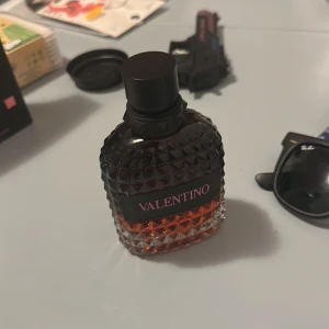 Valentino parfym med nitar - Säljer en lyxig parfym från Valentino i en cool, mörk glasflaska med nitar och svart etikett. Flaskan har en snygg övergång från svart till bärnstensfärgat glas och känns riktigt exklusiv. Perfekt för dig som gillar stilrena och trendiga dofter.