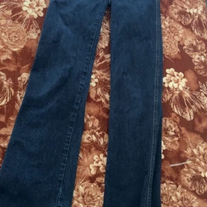 Mörkblå utsvängda jeans - Mörkblåa jeans används inte längre jätte snygga det är storlek xs och xss men dom är jätte snygga och fina rekommenderar verkligen.. Snygga mörkblå jeans med klassisk rak passform. Jeansen har fem fickor och är tillverkade i ett robust denimtyg. Perfekta för dig som gillar en tidlös och enkel stil.