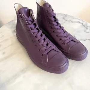 Converse Chuck Taylor All Star - Limited Edition Purple Monochrome (Strl 42,5) - Säljer ett par helt nya o helt oanvända Converse Chuck Taylor All Star - Limited Edition Purple Monochrome (Strl 42,5) skor som är de mycket ovanliga Converse Chuck Taylor All Star i en exklusiv monokrom lila färg. Skorna är limiterade och mycket svåra att få tag på idag, särskilt i storlek 42,5. 	•	Skick: Helt nya och oanvända 	•	Storlek: EU 42,5 	•	Färg: Hel-lila (sula, ovandel, snören – allt ton i ton) 	•	Material: Gummi/konstläder-look med vattenavvisande yta 	•	Modell: High-top (hög modell)