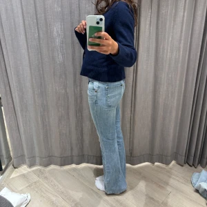 Ljusblå bootcut jeans - Säljer ett par ljusblå lågmidjade jeans med bootcut passform och klassisk femficksdesign. Jeansen har normal midja och är tillverkade i mjukt denimtyg 