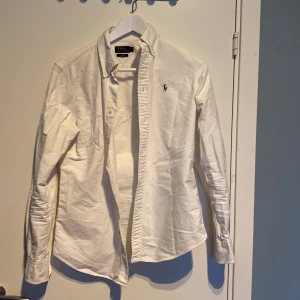 Vit skjorta från Polo Ralph Lauren - Säljer nu den här sjukt feta ralph luren skjortan i storlek S. Med ett lite tunnare bomullsmaterial så är den skön mot kroppen och perfekt för sommaren.  Passar dig som är 165-175 ungefär. Har ni frågor om skjortan kan bi höra av er🙏