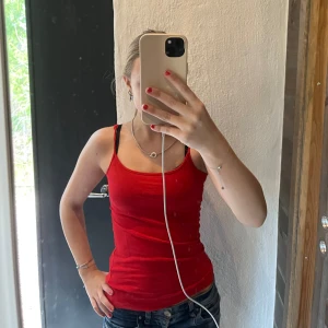 Röd linnetopp från Amisu - Säljer en enkel och snygg röd linnetopp från new yorker i storlek XXS. Toppen har smala axelband och en klassisk rak passform. Perfekt att matcha med jeans eller kjol för en stilren look.