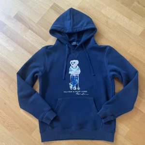 Ralph Lauren Hoodie - Nu säljer jag denna as snygga hoodie ifrån Ralph Lauren med en ikonisk Björn på. Skicket är fortfarande väldigt bra. Storlek M men passar S mer. Hör av er vid minsta fundering. 