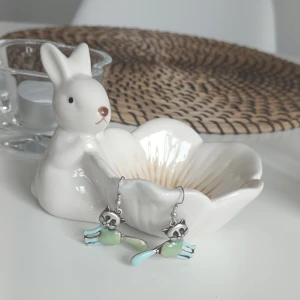 Söta kattörhängen i silverfärgat och mintgrön - Charmiga örhängen med kattmotiv i silver och mintgrön färg. Perfekta för kattälskare som vill ha en lekfull touch till sin stil. Örhängena har en unik design med detaljerade ansikten och svansar. Strass! 