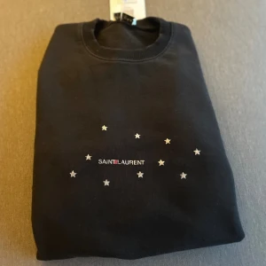Saint Laurent Tröja - Riktigt schysst Saint Laurent Sweatshirt som tyvärr har blivit knäppet för liten men sitter bra i Size S. Köpt på Vestiaire Collective samt verifierad att den är äkta | Bra skick | Färgen är svart med en riktigt skön vintage tvätt | Nypris ca. 5000-7000kr. Tveka inte på att fråga vid funderingar eller intresse! /Axel