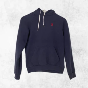Marinblå hoodie från Ralph Lauren - Säljer en riktigt snygg marinblå hoodie från Ralph Lauren med den klassiska röda logotypen på bröstet. Den är i perfekt skick och i storlek XXS men kan även passa XS. Vid några frågor eller funderingar är det bara att höra av sig.