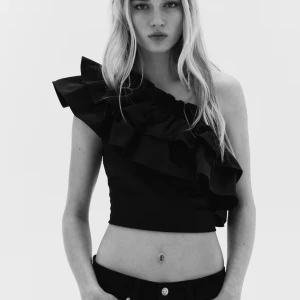 Svart off shoulder topp med volang - Säljer denna populära svarta topp med volang i storlek M. Ny med prislapp